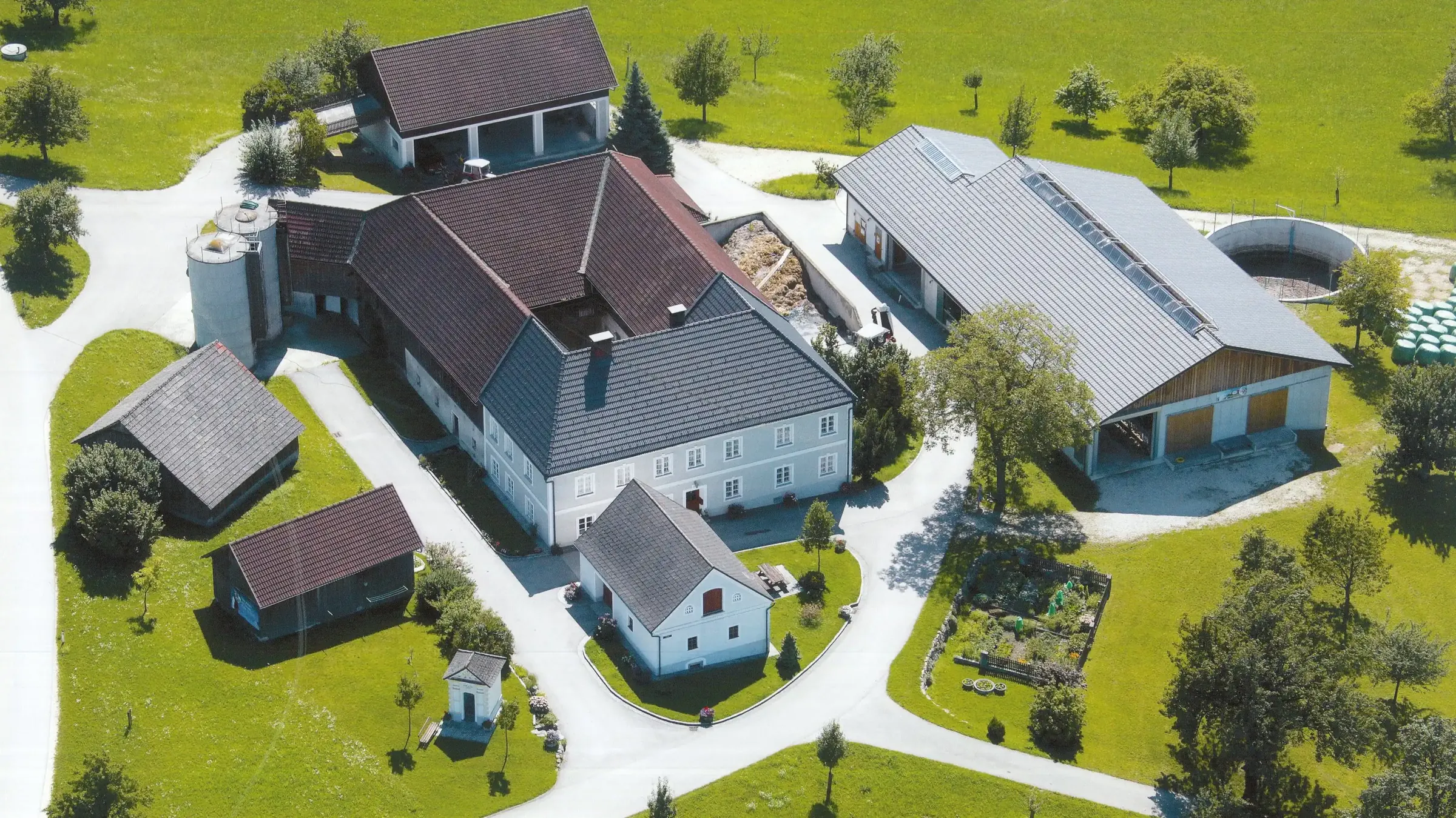 Luftbild des Wegbauernhofs mit Vierkanthof, Kuhstall und Nebengebäuden